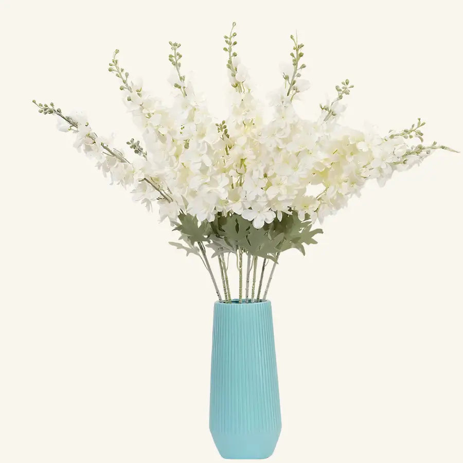 Vase turquoise texturé avec delphinium blanc artificiel luxuriant