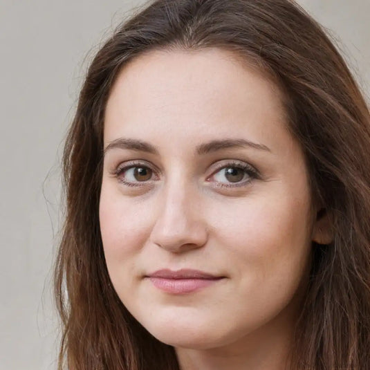 Une femme aux longs cheveux bruns ondulés et aux yeux noisette chaleureux.