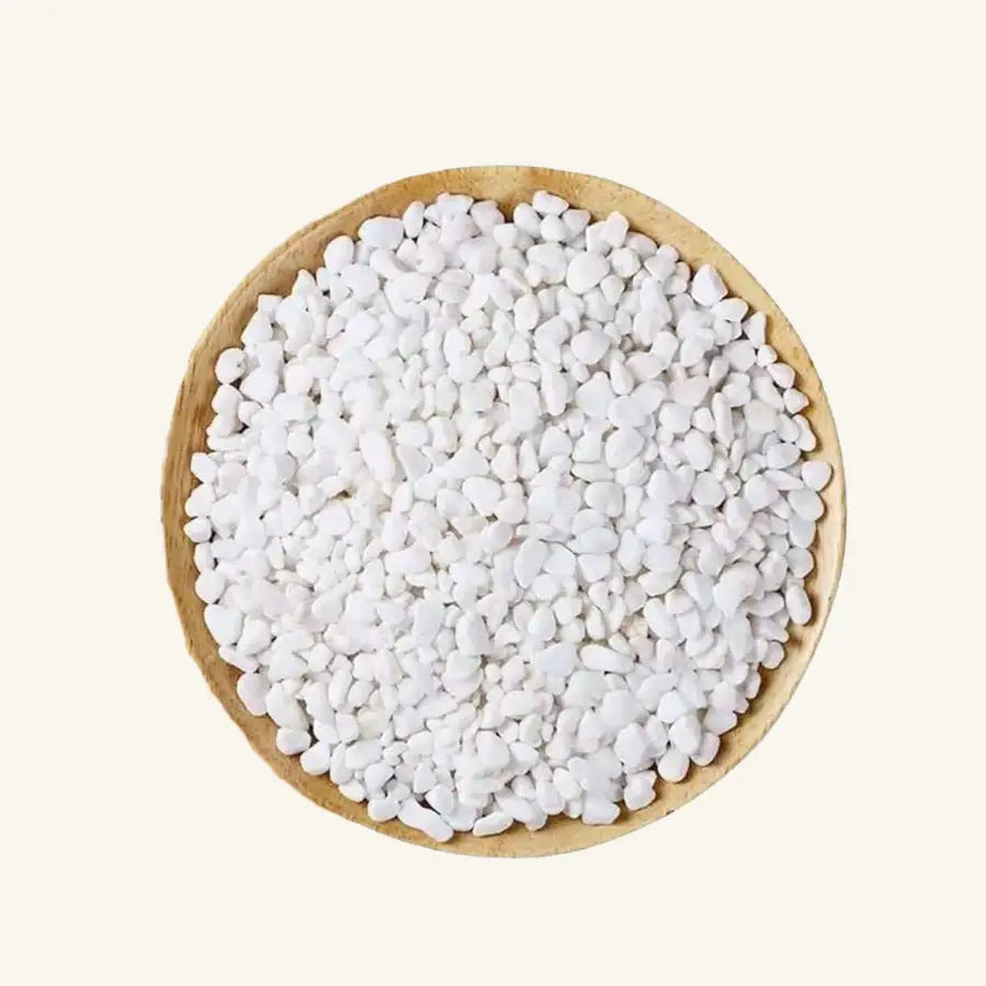 Bol en bois brun rempli de galets décoratifs blancs ronds