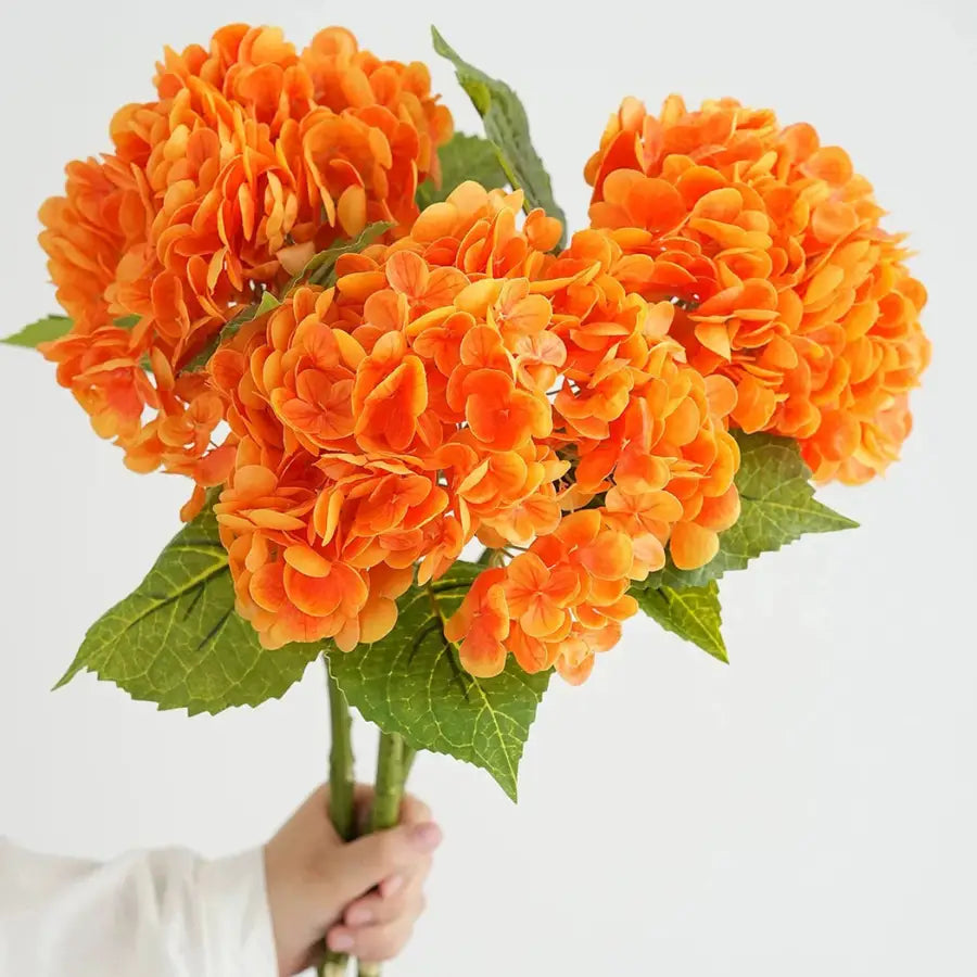 Bouquet de Hortensia Orange artificiel vibrant, tenu en main