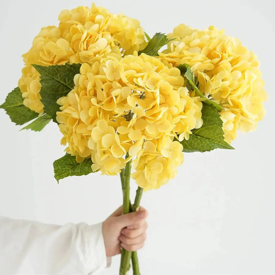Bouquet vibrant de hortensias jaunes artificiels aux feuilles vertes luxuriantes